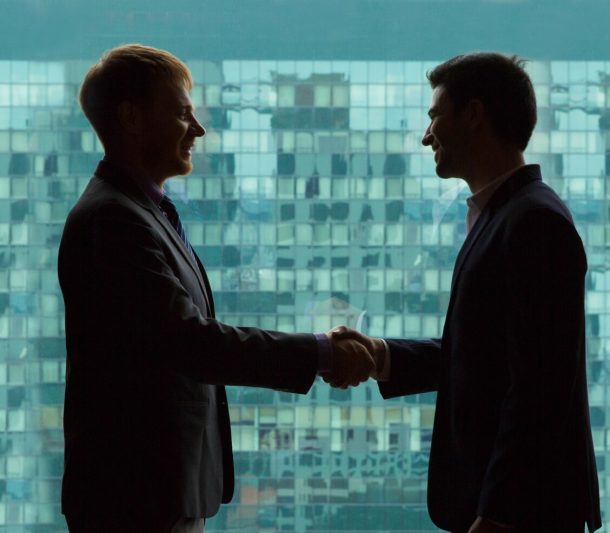 business-people-shaking-hands-with-green-background-office-buildings_1262-792